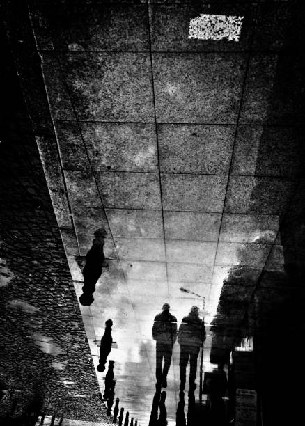 istock Monochrome view of reflection of two men on sidewalk 969549996