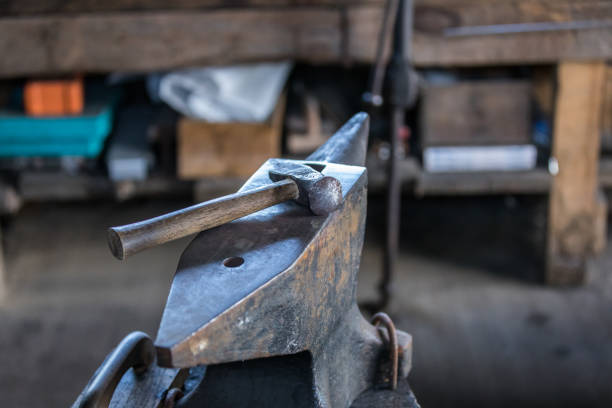 Blacksmith boy working on the anvil changing the horseshoe to a leg with tools