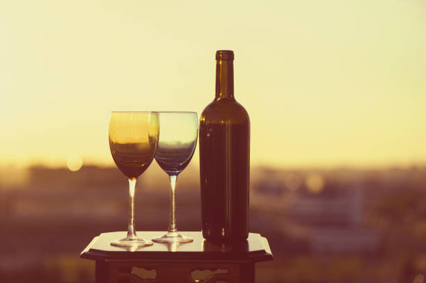 istock bottle of wine and two glasses on a sunset background 969556390