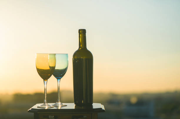 istock bottle of wine and two glasses on a sunset background 969556416