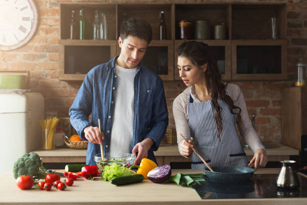 istock Happy couple cooking healthy dinner together 969559466