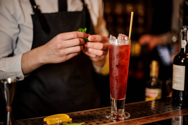 istock Barman adding the mint leaves to the fresh red cocktail 969563934