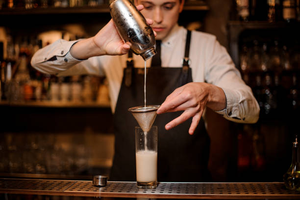 istock Bartender pouring an alcoholic drink from the steel shaker 969564044