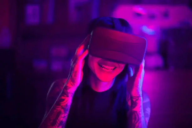 Photo of Young woman looks fascinated into Virtual Reality Headset