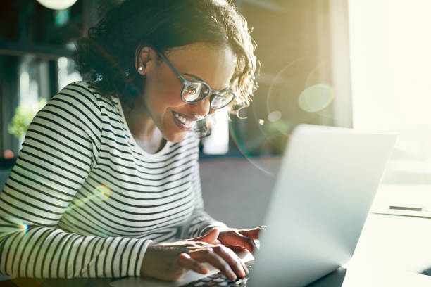 istock Young African woman smiling and using a laptop 969579162