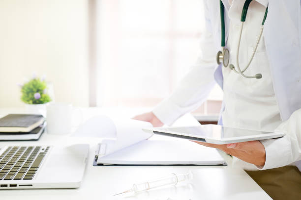 istock Medical Technology , Close up doctor reading a report in tablet computer on workplace. 969579416