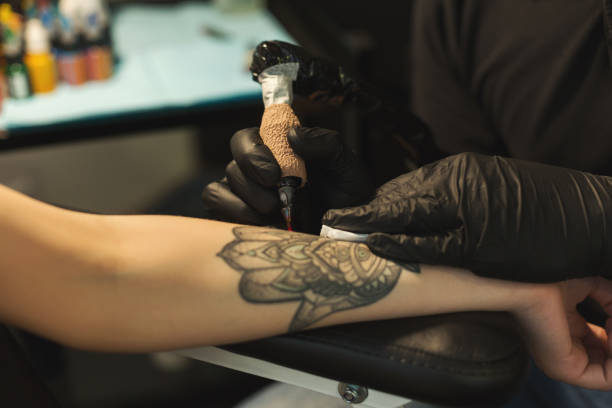 istock Professional tattoo artist making tattoo on hand 969583152