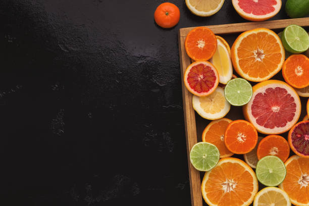 istock Variety of ripe citruses on black background 969583576