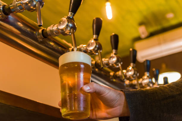 Beer being taken from the tap in brewpub, craft beer, hand of man serving beer.