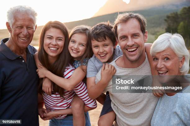 Ritratto Di Famiglia Multigenerazionale In Campagna A Piedi Sul Lago - Fotografie stock e altre immagini di Famiglia