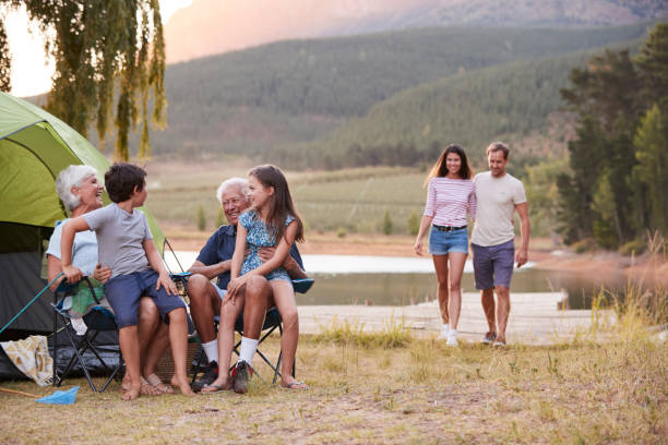 multi generation family on camping trip by lake together - camping tent offspring 60s imagens e fotografias de stock