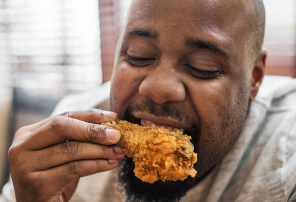 istock Man eating a piece of fried chicken 969591506