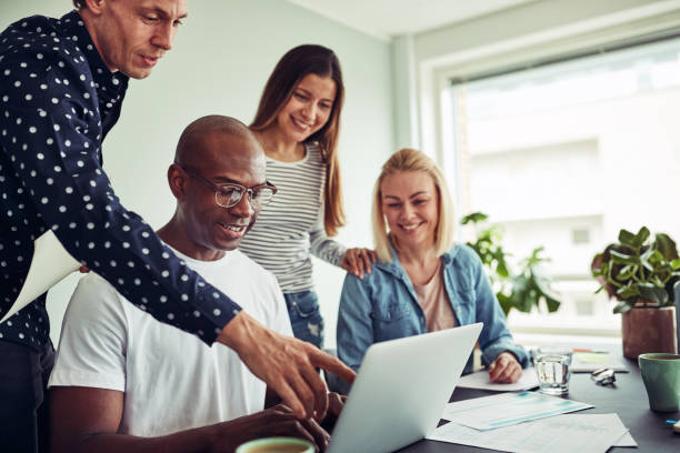 istock Smiling diverse businesspeople talking together over a laptop 969597034