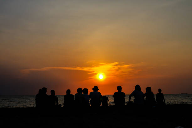 istock silhouette family sit and looking sunset on beach 969599950