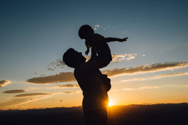 istock Father holding son high up at sunset 969613876