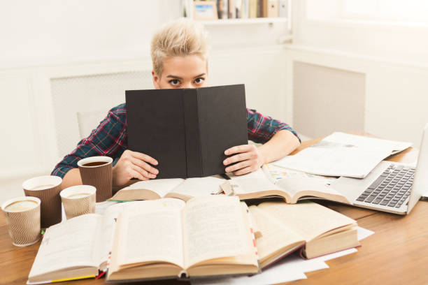 istock Student girl studying at table full of books 969618948