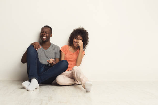 istock African-american couple hugging, sitting on floor 969623840