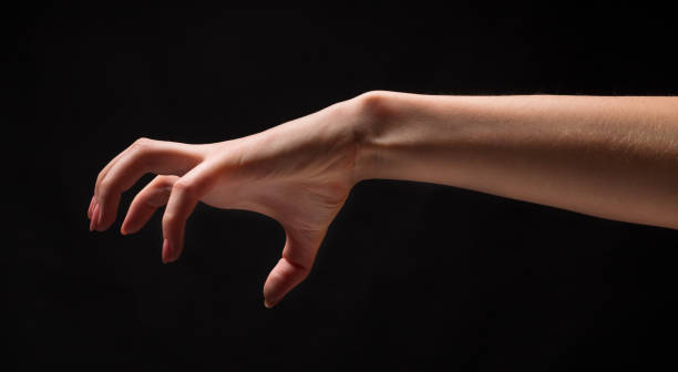 istock Female hand picking up something, cutout on black 969625080