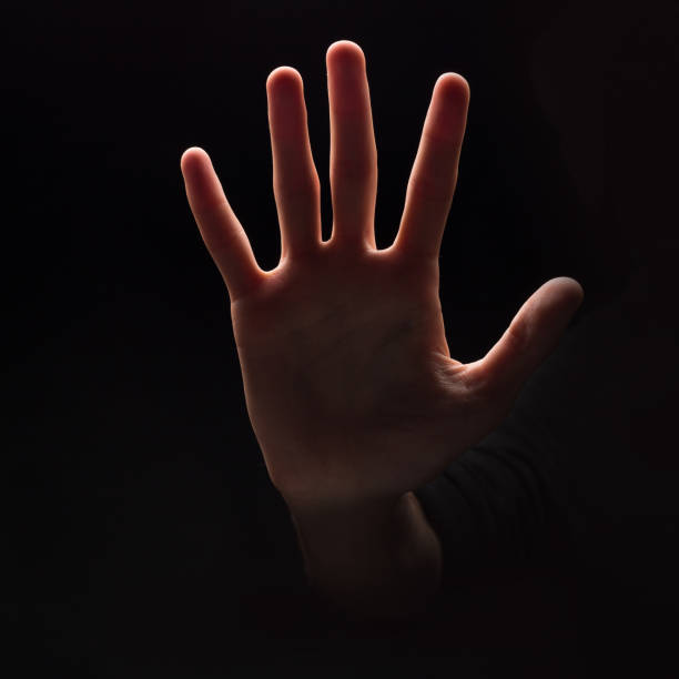 Man making stop sign with his hand at black background