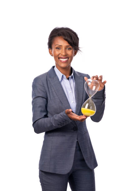 business woman holding hourglass. - businesswoman black african descent studio shot imagens e fotografias de stock
