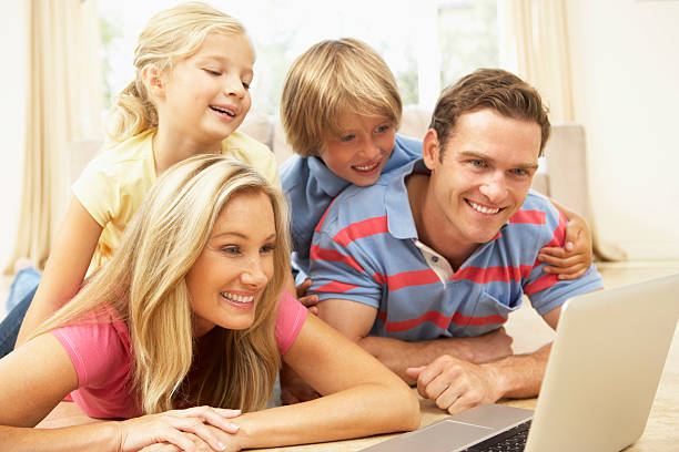 istock Family of four smiling while using a laptop 96964308