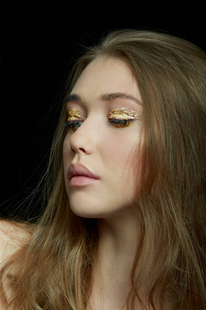istock BLONDE GIRL WITH GOLD EYESHADOW ON BLACK BACKGOUND 969647816