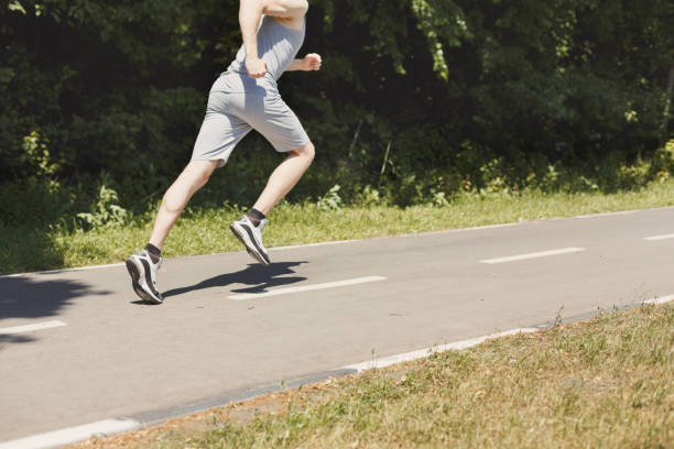 istock Young man jogging on treadmill in park, copy space 969647970