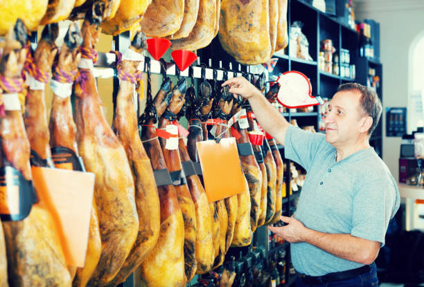 istock Mature man customer selecting Spanish jamon leg 969649506