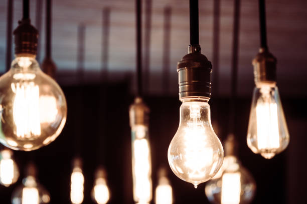 istock Close-Up Of Illuminated Light Bulbs Hanging At Night 969655128