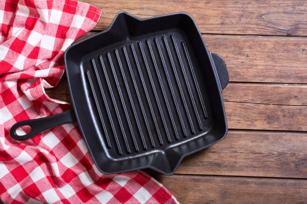 istock empty iron grill pan on wooden table, top view 969660494