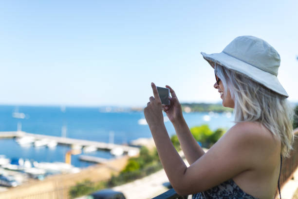 istock Young lady photographing sea 969666170