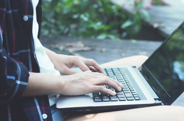 istock beautiful asian woman hands using laptop typing keyboard for working or searching web browser internet online in social network for some data at outdoor in the park. 969668080