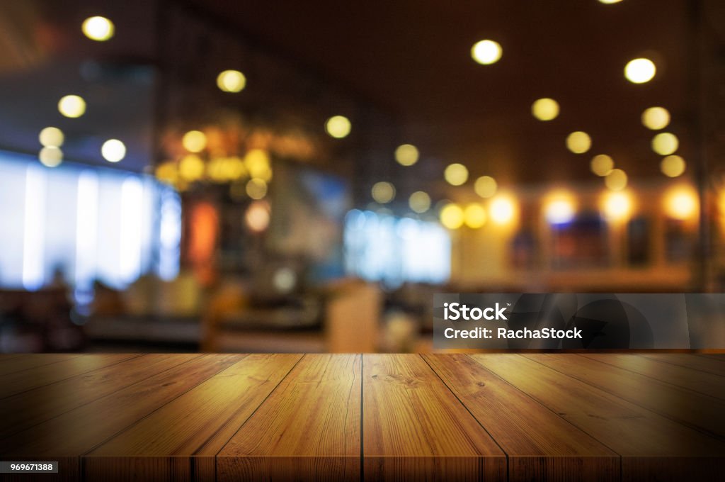 Piano del tavolo in legno vuoto con caffetteria sfocata o sfondo interno del ristorante. - Foto stock royalty-free di Bancone - Bar