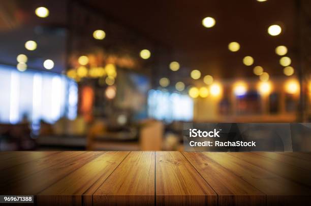 Empty Wooden Table Top With Blur Coffee Shop Or Restaurant Interior Background Stock Photo - Download Image Now