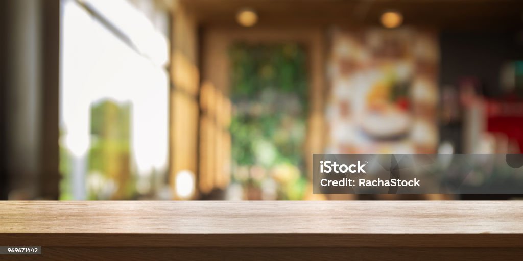 Empty wooden table top with blur coffee shop or restaurant interior background, Panoramic banner. Empty wooden table top with blur coffee shop or restaurant interior background, Panoramic banner. Abstract background can be used product display. Table Stock Photo