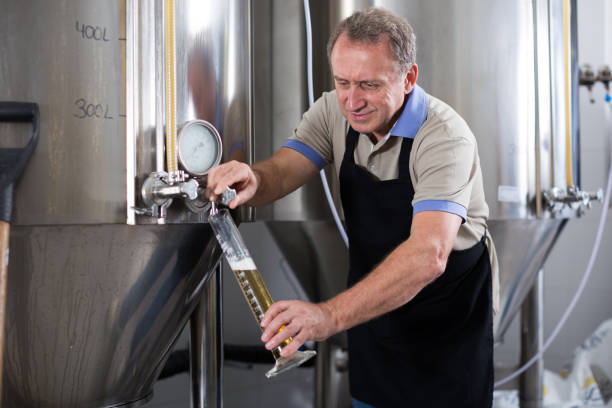 istock Brewer is controlling the quality of beer in flask 969677572