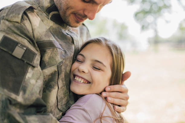 istock Happy girl hugging a soldier 969680988
