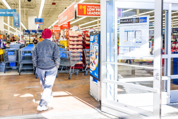 signe de vendredi noir chez walmart magasin entrée avec carte après thanksgiving shopping consumérisme en virginie avec homme sikh qui marche à l’intérieur - walmart photos et images de collection