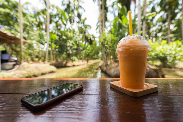 frullato succo d'arancia con smartphone su tavolo di legno - blueberry smoothie milk shake drink foto e immagini stock