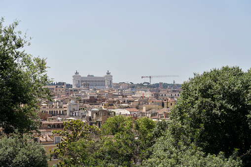 Horizontal view from Pincio with trees in foreground and Altare della Patria in background.