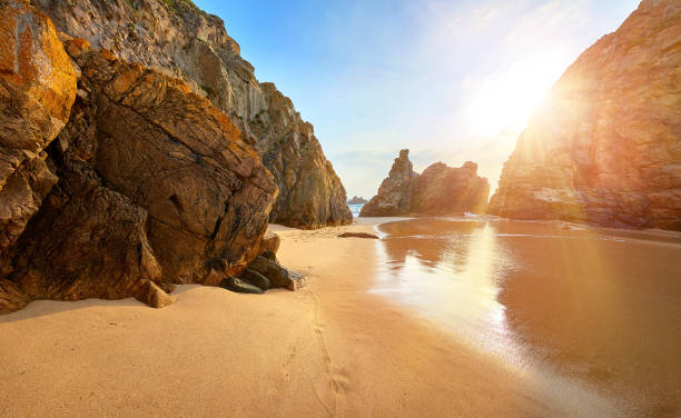 istock Sand beach among rocks on evening sunset 969693278