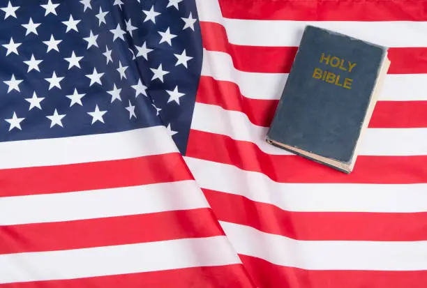 American flag with US constitution or holy bible.