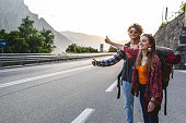 Backpackers hitchhiking on the road