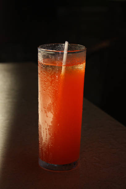 istock Orange drink with straw and dark background 969704524