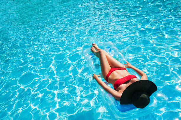 femme reposante sur le matelas gonflable dans la piscine. - outdoor chair furniture travel vacations photos et images de collection