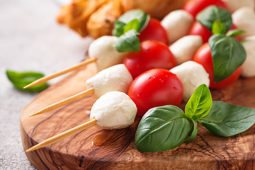 Traditional Italian antipasto caprese skewers and grissini bread