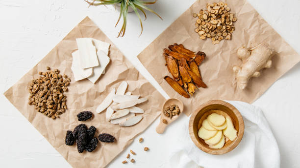 Collection of natural raw herbal ingredients as part of an herbal tonic formula used in Traditional Chinese Medicine (TCM) for cold or flu. This Traditional Chinese Medicine (TCM) herbal formula is known as "Ge Geng Tang," a classic recipe used for treating the common cold and flu. Ingredients include magnolia bark, Chinese almonds, fresh ginger, and black dates. chinese herbal medicine stock pictures, royalty-free photos & images