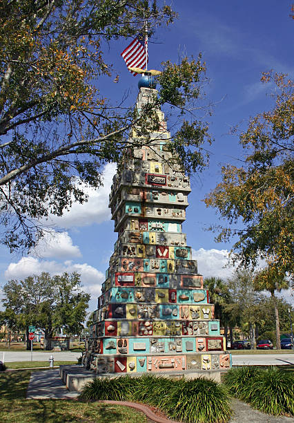 Monument of the States Kissimmee Florida This long time public tourist attraction has been billed as the "World's Most Unique Monument”, the Monument of the States was built during the dark days of WW II of 1,500 stones donated from every state in the U.S.A., with 45 Governors and 21 Foreign Countries contributing. It is 22 ft. square at the base with a height of 50 ft and weighs 600,000 lbs.  Located on Monument Avenue in front of the Community Center, it took 2 years to build from donations which arrived in a variety of formats – blocks of native granite, chunks of quartz, small boulders, fossils, hunks of old buildings and  even a human skull (which was not incorporated into the finished product). In 2001, another year of patriotic fervor, local employers (in the tourist industry) rallied the community to give the Monument a long overdue facelift, complete with a new flag and a fresh coat of paint on some of the supporting slabs. kissimmee stock pictures, royalty-free photos & images