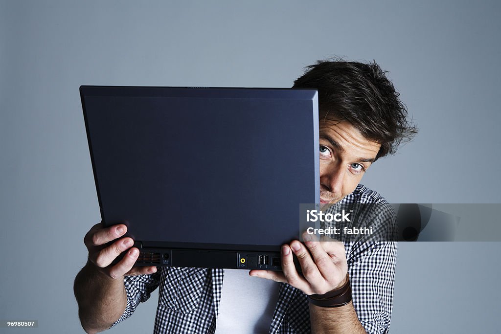 Porträt junger Mann hält einen laptop, Studioaufnahme - Lizenzfrei Hinter Stock-Foto