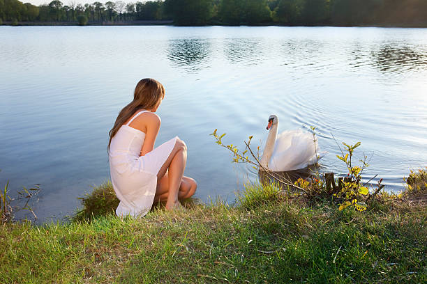 istock blond woman on water background and swan 96980892